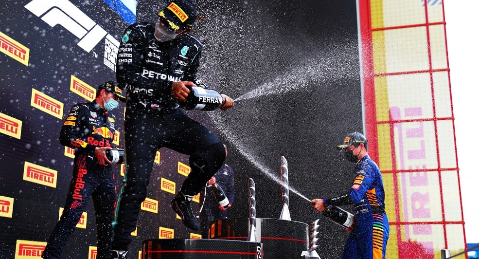 IMOLA, ITALY - APRIL 18: Race winner Max Verstappen of Netherlands and Red Bull Racing, second placed Lewis Hamilton of Great Britain and Mercedes GP and third placed Lando Norris of Great Britain and McLaren F1 celebrate with sparkling wine on the podium during the F1 Grand Prix of Emilia Romagna at Autodromo Enzo e Dino Ferrari on April 18, 2021 in Imola, Italy. (Photo by Dan Istitene - Formula 1/Formula 1 via Getty Images)